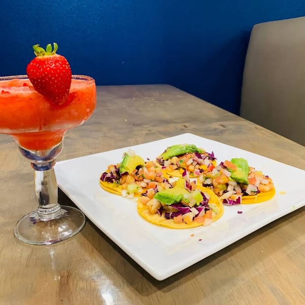 Strawberry margarita and three Mexican tostadas with shrimp, avocado, and red cabbage.
